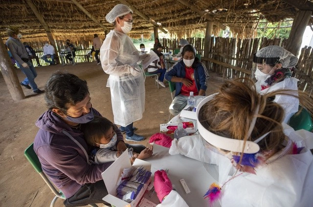 Trabajadores médicos realizan pruebas de detección de Covid-19 a indígenas Guaraní Mimbya, en Cananéia, Brasil. Foto Ap 