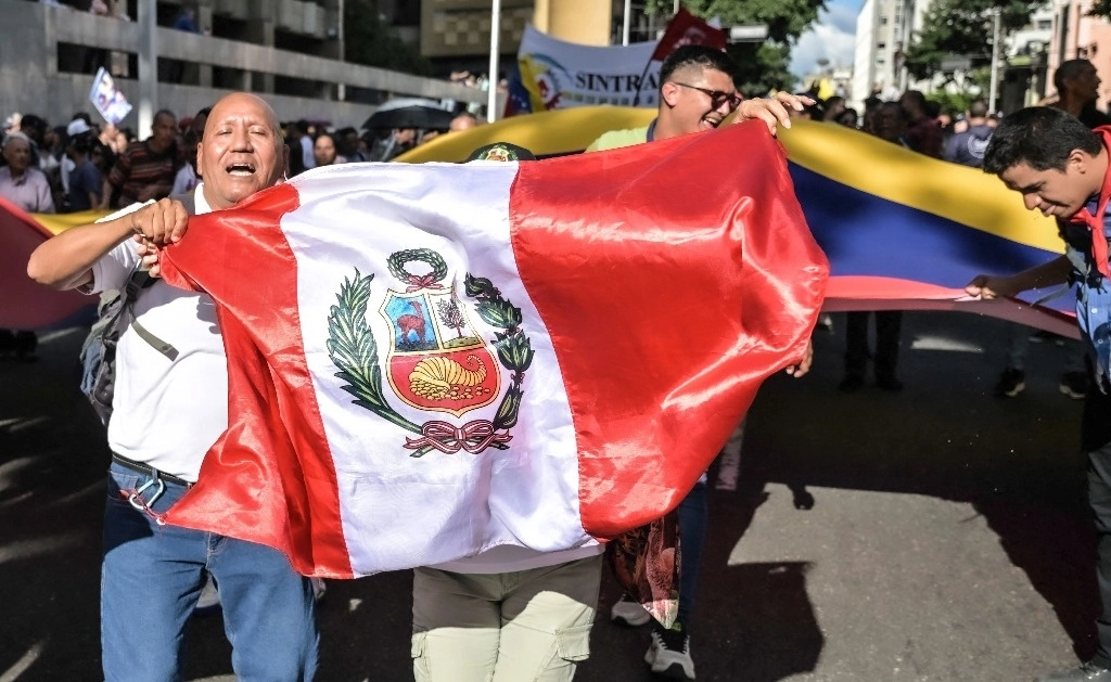 Ondean una bandera de Perú durante una manifestación a favor del presidente venezolano, Nicolás Maduro, en la capital Caracas. Foto Afp 