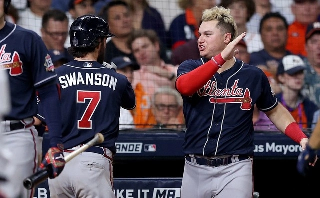 Dansby Swanson (izq) y Joc Pederson (der) de los Bravos de Atlanta festejan una anotación durante el encuentro. Foto Afp