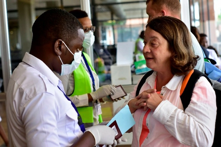 Un trabajador del Departamento de Salud de Tanzania evalúa a un pasajero extranjero que llega al Aeropuerto Internacional de Kilimanjaro, tomando medidas para frenar la propagación del COVID-19. Foto AFP
