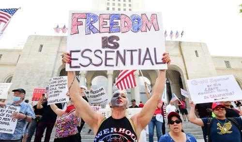 Cientos de manifestantes protestaron ayer frente al edificio del Poder Legislativo de Los Ángeles, en EU, para que se le exija a la alcaldesa levantar el confinamiento por la pandemia de coronavirus.Foto Afp