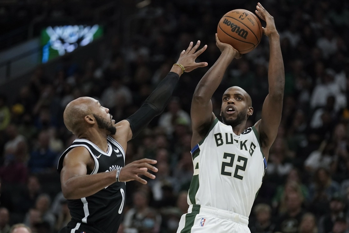 Los Nets extrañaron a Kyrie Irving, quien no está con el equipo debido a que se ha negado a recibir la vacuna contra el Covid-19. En la imagen, Khris Middleton (22) de los Milwaukee Bucks tira sobre Jevon Carter de los Brooklyn Nets durante la primera mitad del partido, el 19 de octubre de 2021. Foto Ap