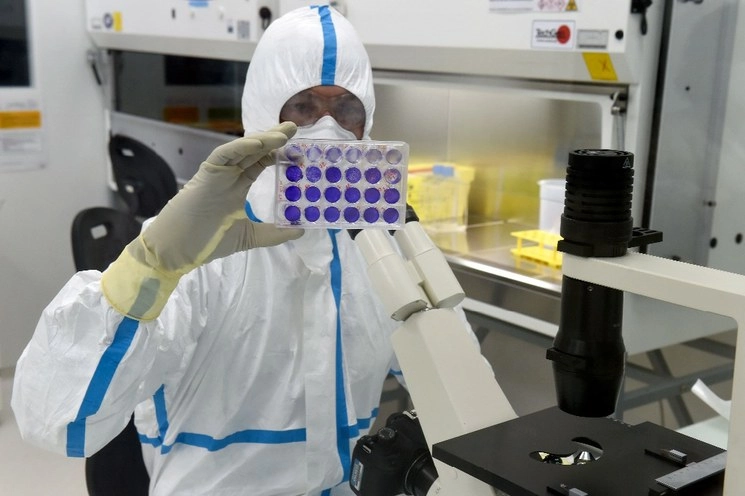 Un virólogo analiza 24 muestras de células infectadas con el virus Sars-CoV-2 en el laboratorio de Bioseguridad de nivel 3 del Grupo Valneva SE en Saint-Herblain, Francia. Foto AFP 