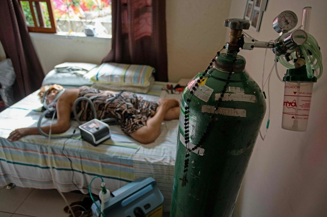 Una paciente de Covid-19 recibe tratamiento en su casa luego de 15 días en un hospital de Manaos, Brasil. Foto Afp