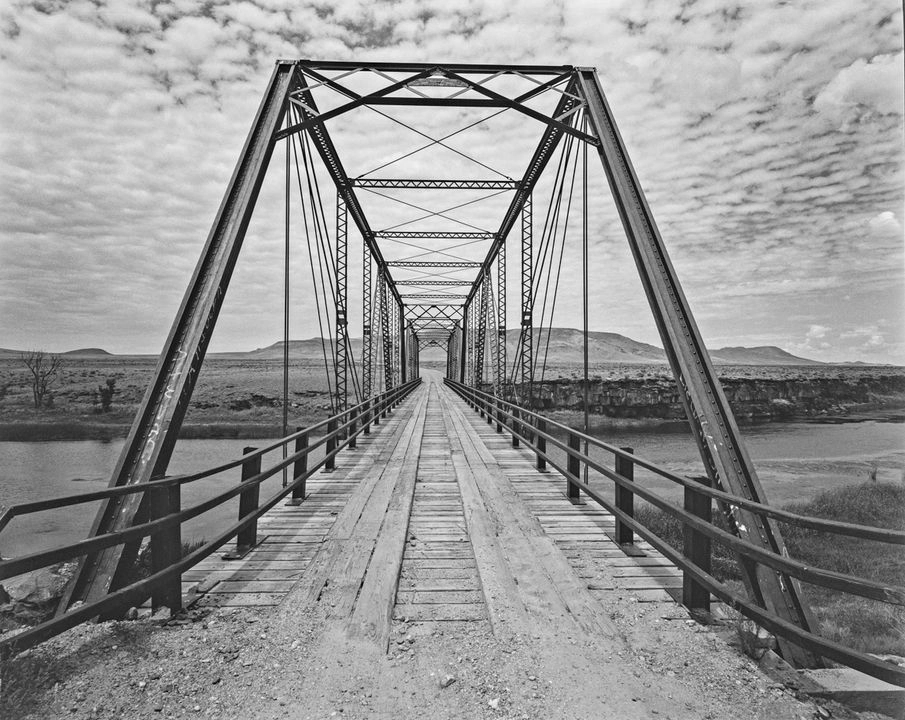 Puente Lobatos, estructura de acero que cruza un río con un paisaje montañoso ubicado sobre el río Grande, en Colorado, Estados Unidos.