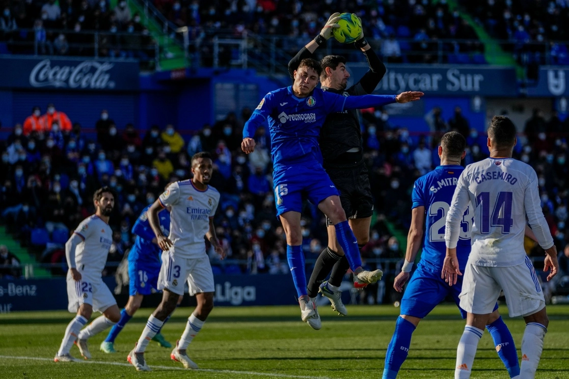 El portero del Real Madrid, Thibaut Courtois, atrapa el balón junto a Jorge Cuenca del Getafe durante el partido de La Liga en el estadio Coliseum Alfonso Pérez de Getafe, España, el domingo 2 de enero de 2022. Foto Ap