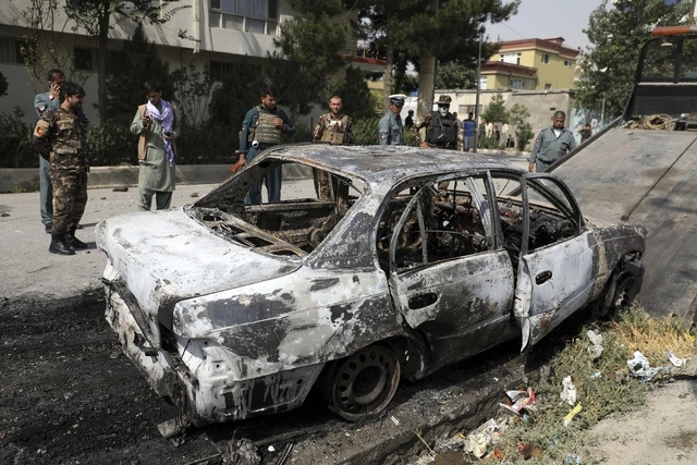 Personal de seguridad inspecciona un vehículo dañado desde el cual se dispararon los proyectiles en Kabul. Foto Ap