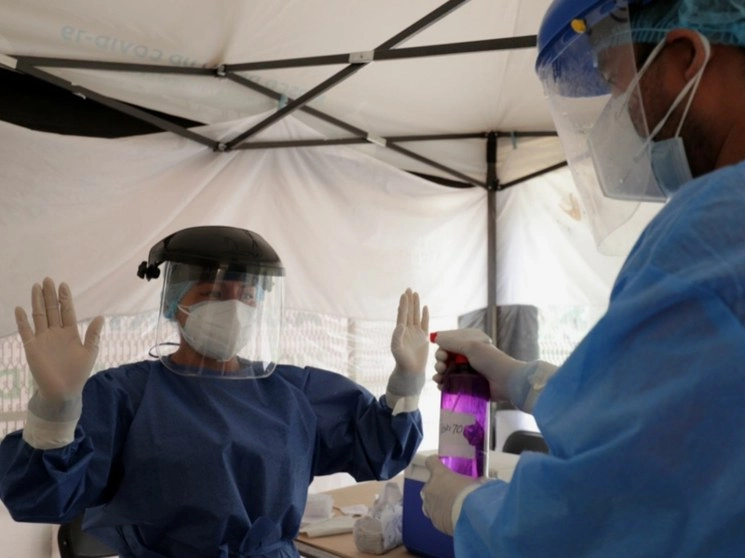 Personal de salud desinfecta su equipo de trabajo antes de realizar pruebas de Covid en la Ciudad de México. Foto Roberto García Ortiz