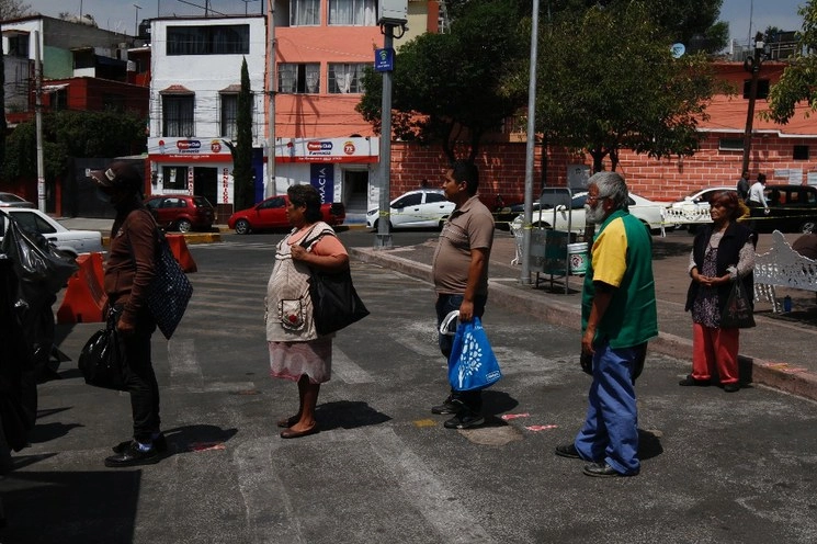 Personas hacen fila para recibir una comida gratuita ofrecida por un Comedor Móvil Público a personas que se encuentran en área de la zona de hospitales, en Tlalpan. Foto Cristina Rodríguez / Archivo