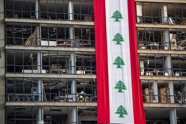 Uno de los edificios dañados por las explosiones en Beirut, con la bandera libanesa. Foto Ap 