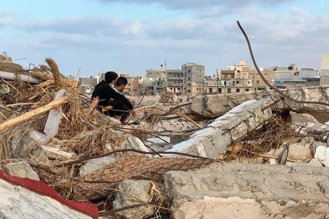 Personas sobre los escombros en la ciudad Libia de Derna, tras días de las inundaciones que devastaron la ciudad. Foto Afp 