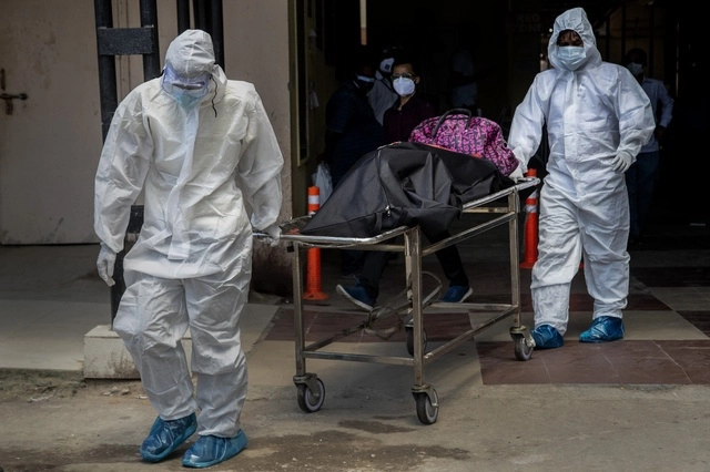Trabajadores de la salud con trajes de protección contra el Covid-19, en un hospital gubernamental en Gauhati, India. Foto Ap