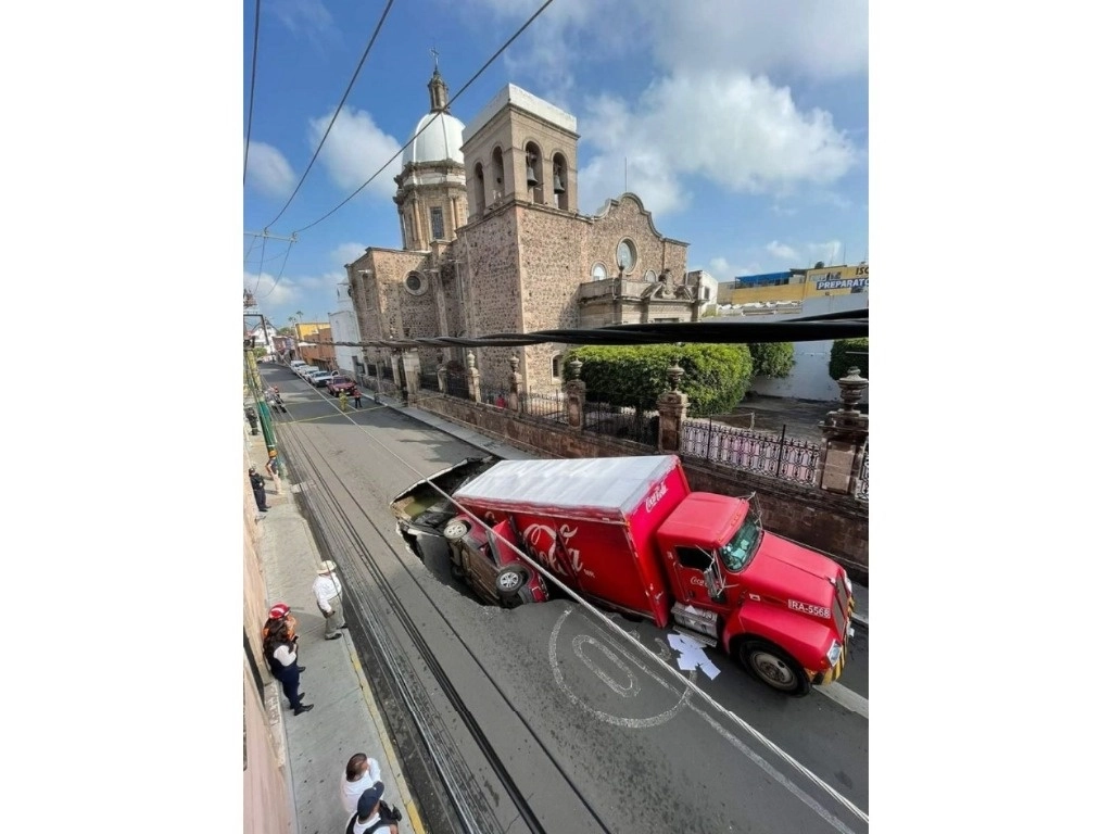 Dos vehículos cayeron al socavón que se formó en calles de la ciudad de Irapuato, Guanajuato. Foto 'La Jornada'
