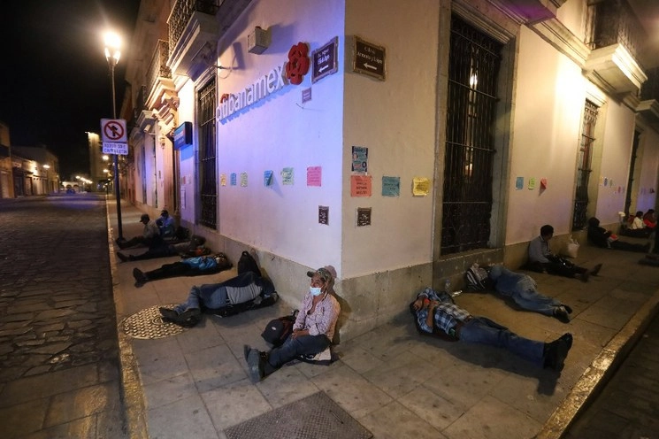 Unas 50 personas, provenientes de diversas localidades del estado, pernoctaron en el exterior de la sucursal Citibanamex ubicada en la calle de Hidalgo esquina Armenta y López, debido a que durante el martes no pudieron cobrar los apoyos de Producción para el Bienestar. Foto Jorge A. Pérez Alfonso