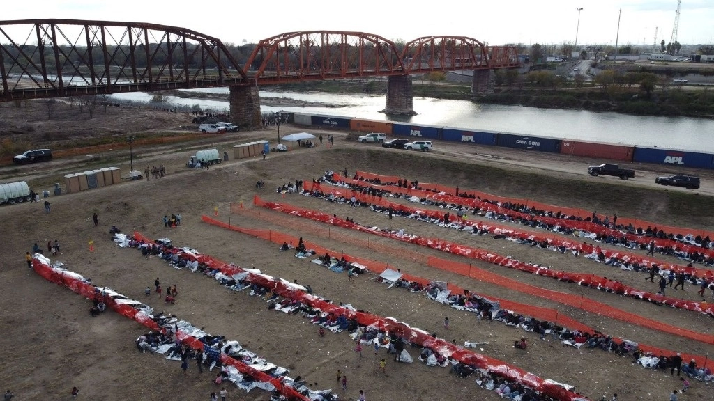 Migrantes esperan ser procesados en un centro de tránsito de la Patrulla Fronteriza estadunidense, después de cruzar la frontera desde México en Eagle Pass, Texas, el 20 de diciembre de 2023. Foto Afp