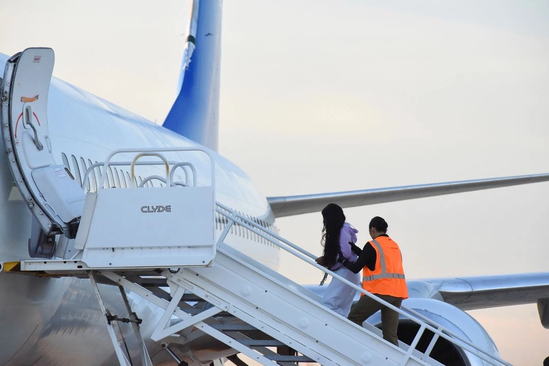 Migrantes venezolanos abordan un avión rumbo a su país de origen desde Harlingen, Texas, el miércoles 18 de octubre de 2023.  Foto