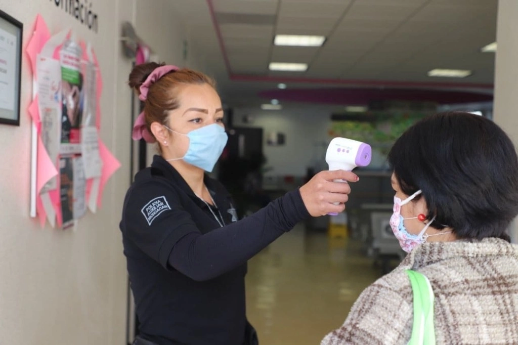 Medición de la temperatura para detectar posibles síntomas de Covid-19 en un filtro sanitario en Michoacán. Foto Tomada del Twitter @SALUDMICH 