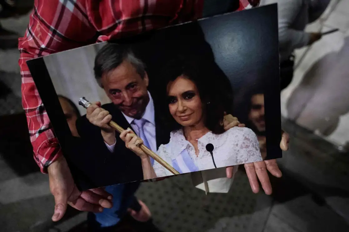 Un simpatizante muestra una foto de la vicepresidenta Cristina Fernández y su esposo, el ex presidente Néstor Kirchner, durante un mítin en Buenos Aires el pasado 25 de agosto. Foto Afp.