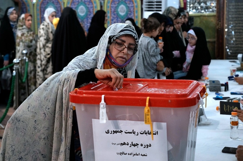 Una mujer emite su voto para las elecciones presidenciales en un colegio electoral en el santuario de San Saleh, en el norte de Teherán, Irán, el viernes 5 de julio de 2024. Foto Ap