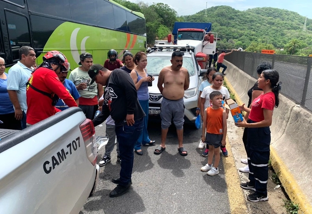 La congestión vehicular de ayer en la autopista Manzanillo-Colima fue ocasionada por una falla en el sistema de ingreso a la aduana de esa localidad. Elementos de Protección Civil ofrecieron agua y atención médica a las personas que permanecieron varadas durante casi 24 horas en la vialidad. Foto tomada de la página de Facebook El Comentario