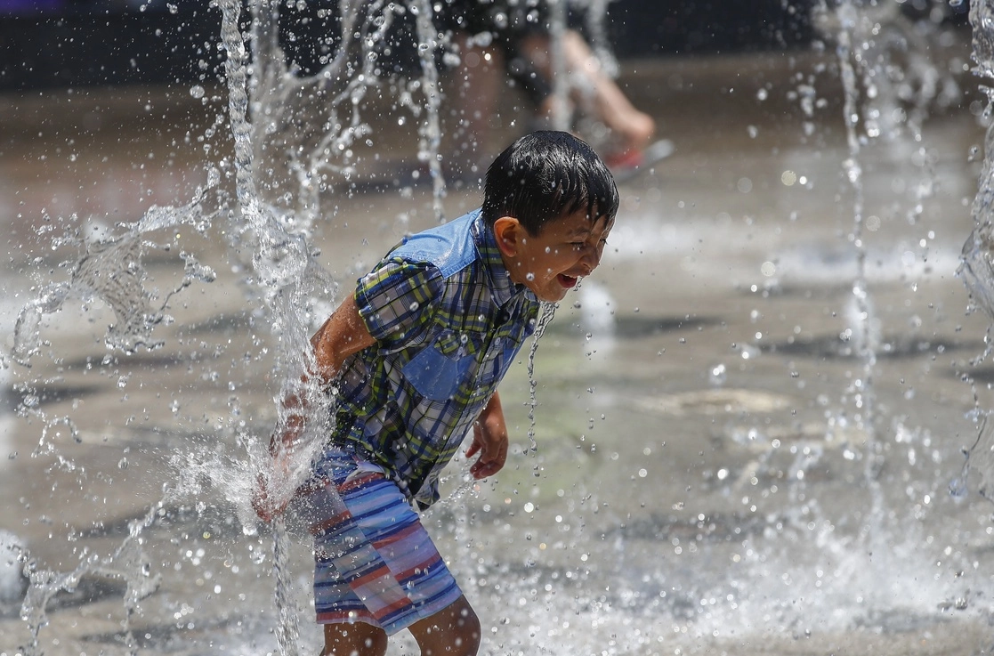 Refrescándose en una fuente. Foto Víctor Camacho/ La Jornada