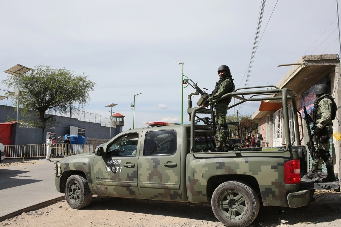Militares vigilan el Centro de Reinserción Social de Tula, Hidalgo, tras la fuga de nueve reos ocurrida el miércoles pasado, en la que además fueron incendiados varios vehículos. Ayer fueron detenidas 11 personas relacionadas con la evasión. La imagen, durante los operativos realizados el pasado 1 de diciembre. Foto Ap