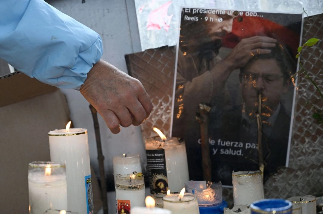 Una mujer enciende una vela en un altar improvisado durante una misa por la salud del senador colombiano Miguel Uribe Turbay, quien recibió un disparo en un evento político hace una semana, en Bogotá, el 14 de junio de 2025.  Foto 