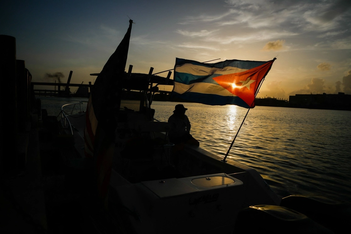 Navegantes en Miami, Florida, ondean en su embarcación la bandera de Cuba para mostrar su apoyo a la isla. Foto Afp