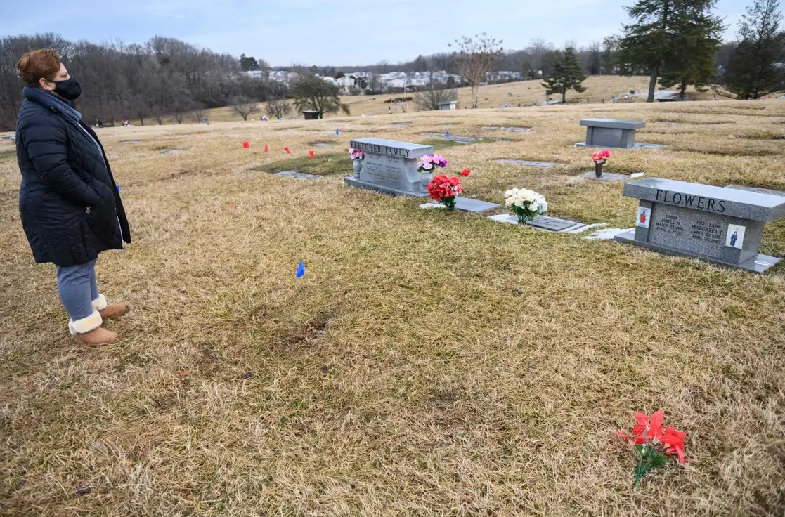 Una mujer visita la tumba de su padre, quien falleció de Covid-19 en abril de 2020, en un cementerio en Hyattsville, Maryland, el 23 de febrero de 2021. Foto Afp