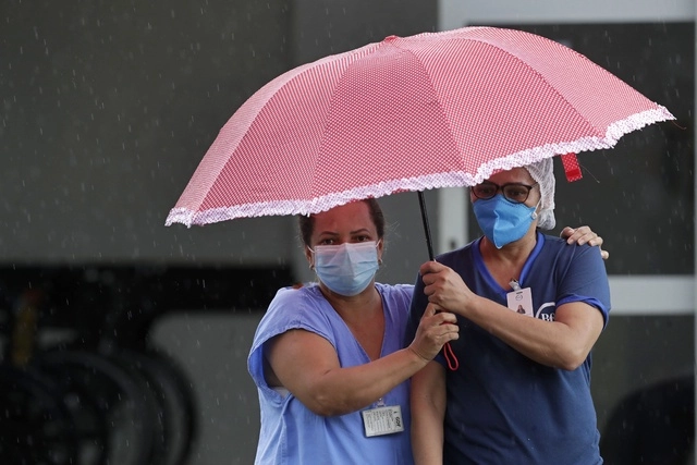 Trabajadoras de la salud esperan la llegada de una ambulancia con un paciente sospechoso de Covid-19, en el hospital HRAN de Brasilia, el pasado 8 de febrero de 2021. Foto Ap 