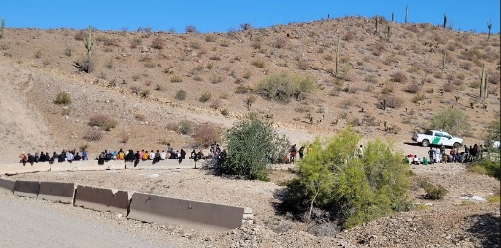 Larga fila de los migrantes asegurados, en la frontera entre EU y México. Foto 'La Jornada' / Archivo
