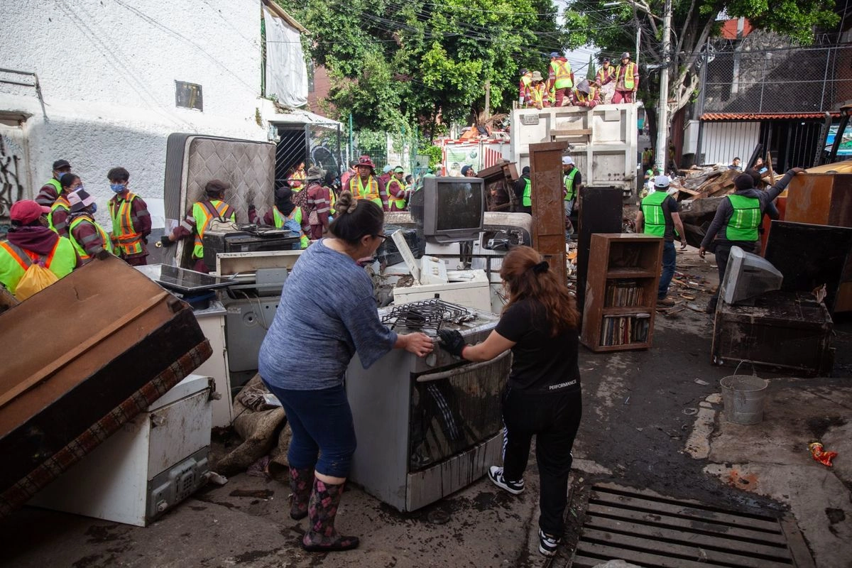 La lluvia del sábado no sólo inundó calles en la alcaldía Magdalena Contreras, sino también provocó un deslizamiento de tierra en zonas con terreno irregular. El gobierno capitalino informó que 80 viviendas resultaron afectadas, 29 de ellas con daños graves, aunque continúa haciendo el censo de damnificados y se activó la cobertura del seguro de desastres. Los vecinos y trabajadores realizaron limpieza; en la imagen, la calle Hortensia.
