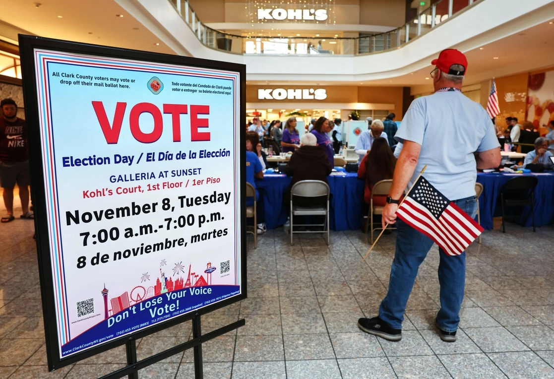 Un trabajador electoral sostiene una bandera estadounidense en un lugar de votación en Galleria at Sunset el 8 de noviembre de 2022 en Henderson, Nevada. Foto Afp