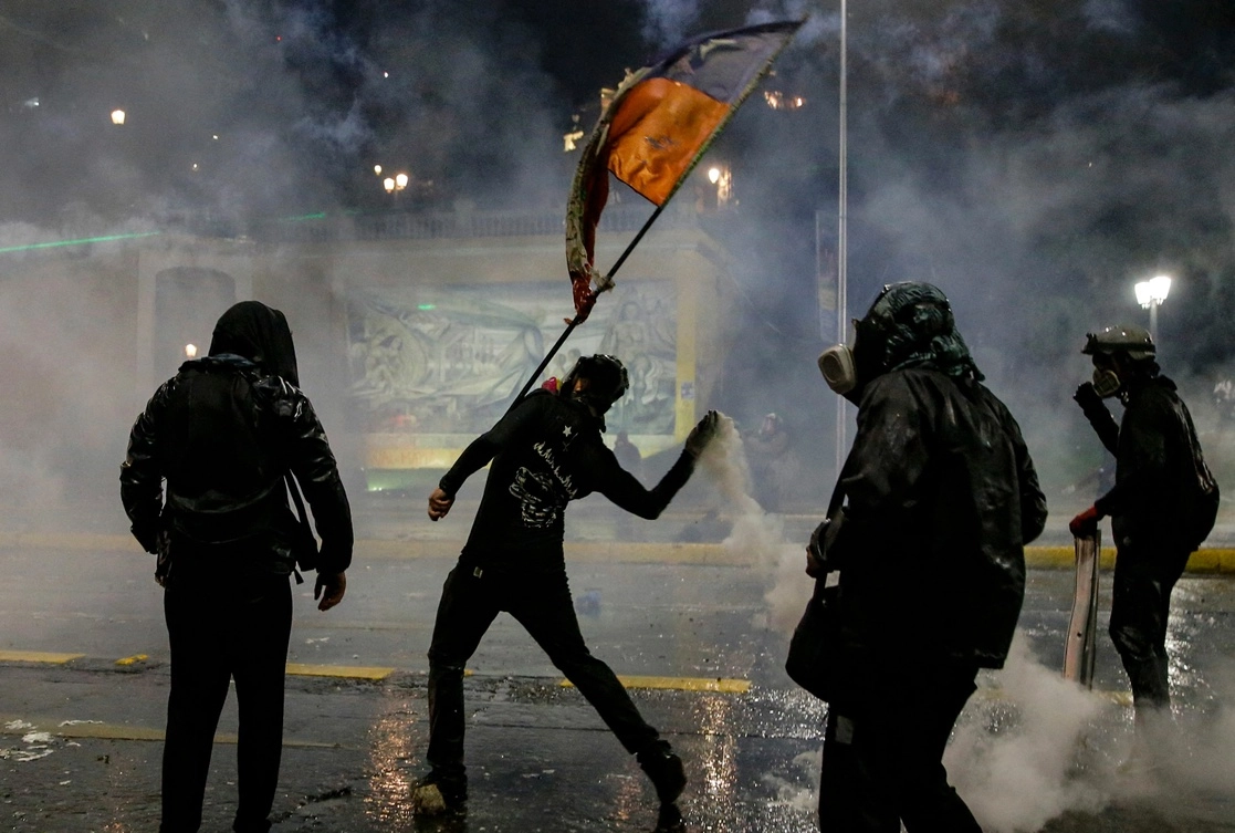 Casi al término de las marchas por el aniversario del 18-O en Santiago, algunos manifestantes enfrentaron a la policía, el 18 de octubre de 2021. Foto Afp