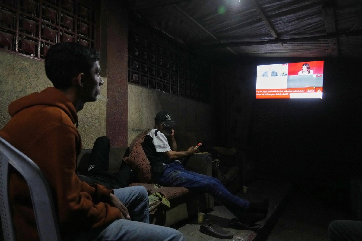 Palestinos observan la televisión tras enterarse del anuncio de que Hamas e Israel firmaron la primera fase del plan de paz propuesto por el presidente de EU, Donald Trump. Foto