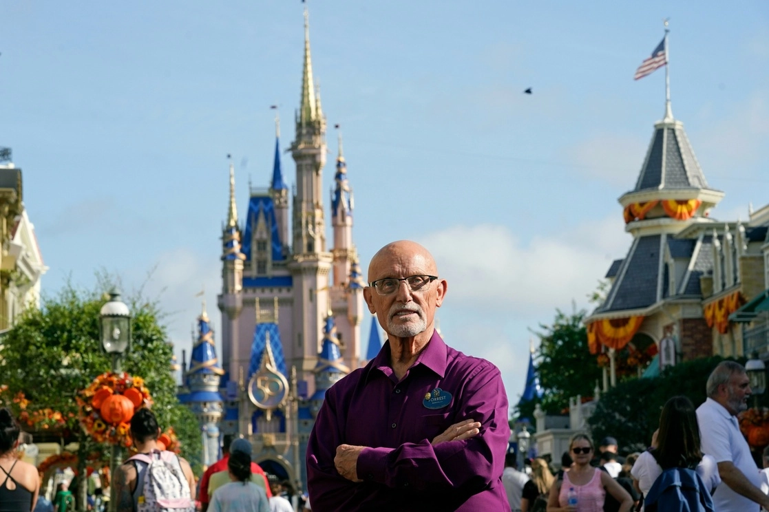 Forrest Bahruth, quien se unió al equipo de Disney World en enero de 1971 como director de espectáculos, continúa trabajando para esa empresa. En la imagen posa frente al Castillo de Cenicienta, ubicado en el Margic Kingdom, en Lake Buena Vista, Florida, el 30 de agosto de 2021. Foto Ap 