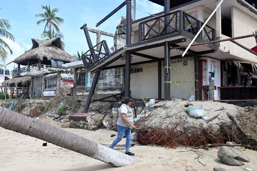La Presidencia informó que comenzó el censo de damnificados que dejó el huracán 'John' en Guerrero y Oaxaca. En la imagen, una empleada de la Secretaría del Bienestar recorre Pie de la Cuesta. Foto Afp