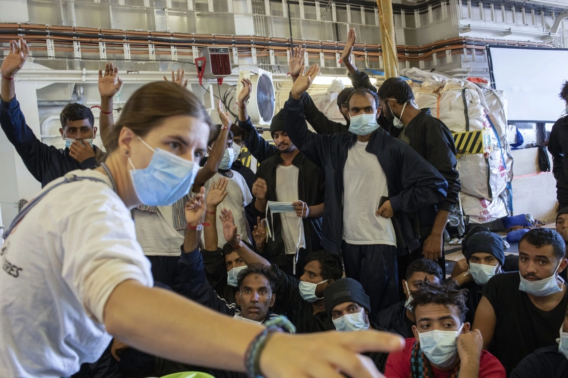 Migrantes esperan a bordo del barco de rescate Geo Barents con bandera noruega a que las autoridades italianas decidan si se les permitirá desembarcar, en el puerto de Catania, Sicilia. Foto Ap / Massimo Di Nonno