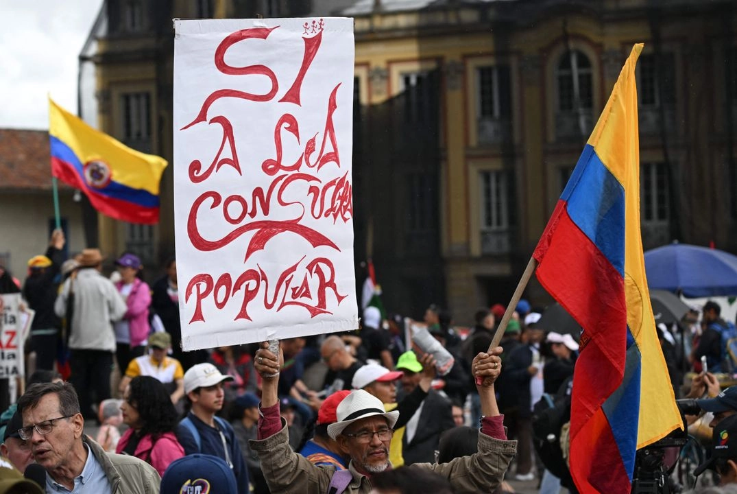 Un hombre sostiene un cartel en apoyo a la consulta popular durante una marcha a favor de las reformas propuestas por el presidente de Colombia, Gustavo Petro, en el marco de una huelga convocada por los sindicatos en Bogotá, el 28 de mayo de 2025. Foto 