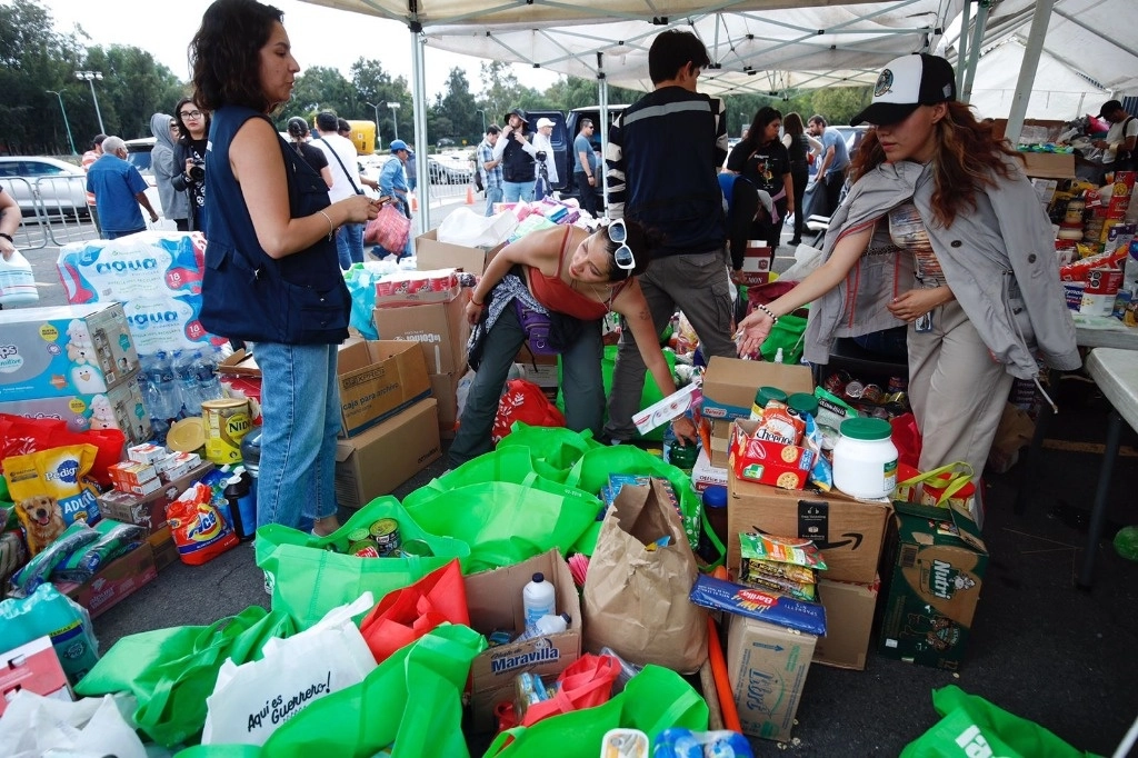 Voluntarios ayudan acomodar los productos que donan las personas en el centro de acopio ubicado junto al asta bandera del Estadio Olímpico Universitario UNAM. Foto Cristina Rodríguez/ Archivo