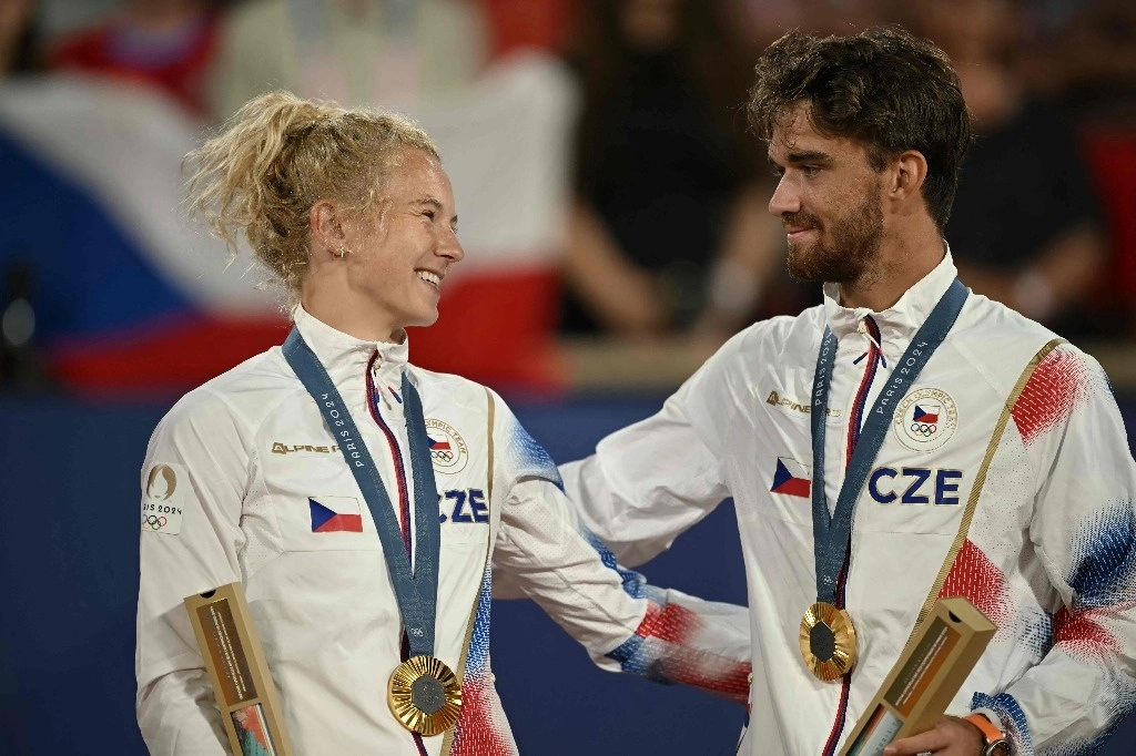 Los medallistas de oro, Katerina Siniakova de la República Checa y Tomas Machac de la República Checa, posan con sus medallas en el podio en la ceremonia de presentación del evento de tenis de dobles mixtos. Foto Afp