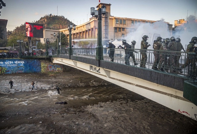 Durante una protesta en Santiago de Chile carabineros arrojaron a un joven de 16 años al río. Foto Ap