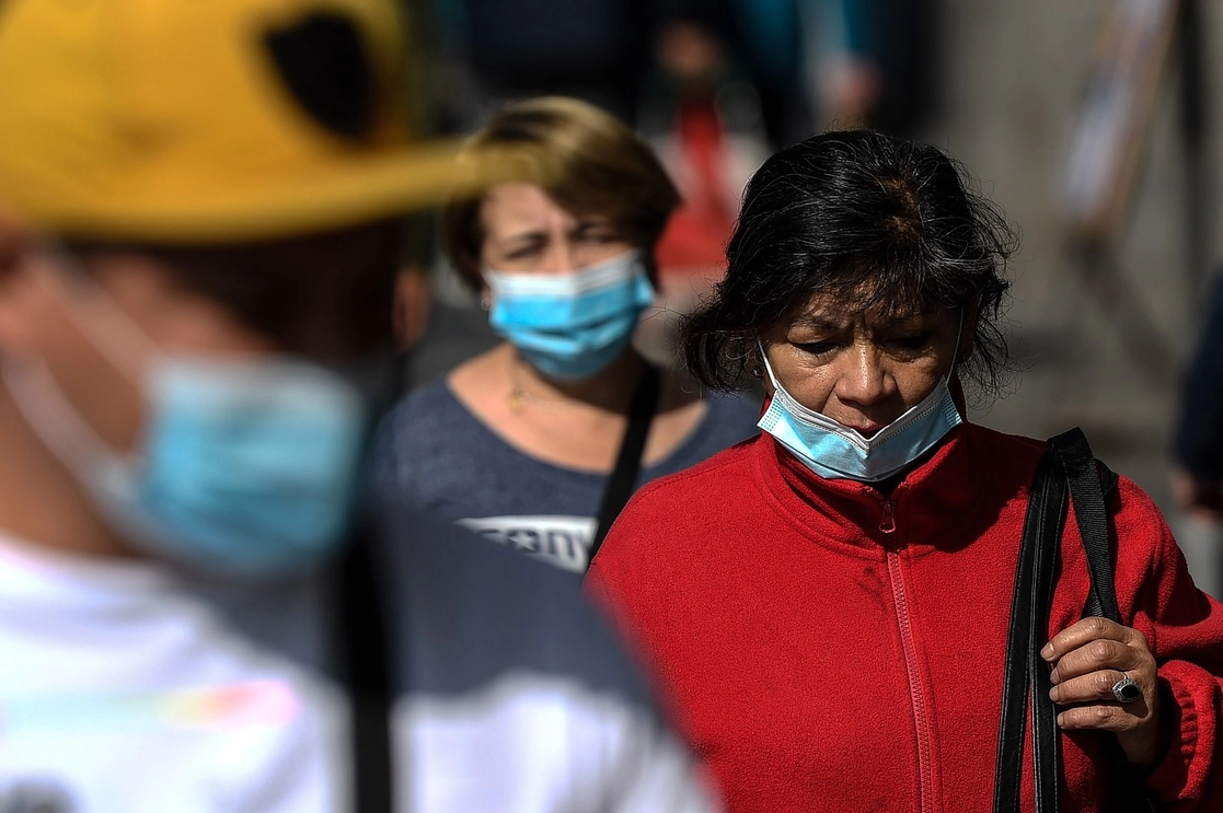 Chilenos, que usan cubrebocas, caminan por una calle de la ciudad de Santiago, el 29 de abril de 2022. Foto Xinhua