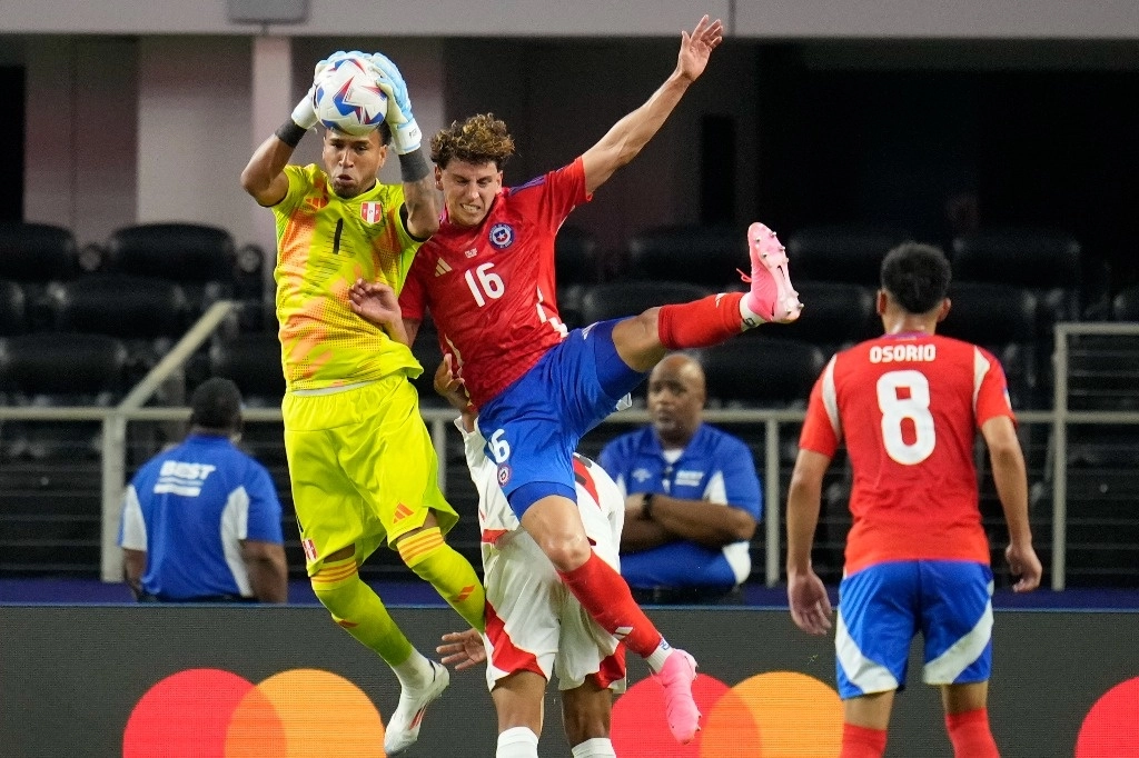 El portero peruano Pedro Gallese, de 1 año, atrapa un balón junto al chileno Igor Lichnovsky durante un partido de fútbol del Grupo A de la Copa América en Arlington, Texas, el 21 de junio de 2024. Foto Ap