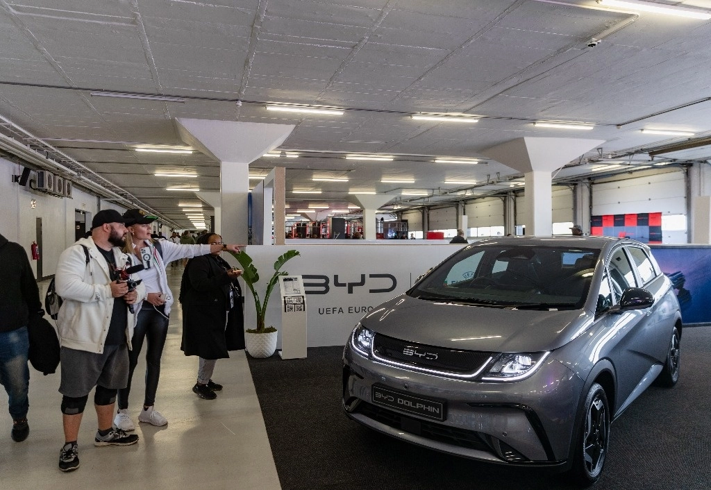 Personas observan un auto eléctrico de la marca china BYD. Foto Xinhua