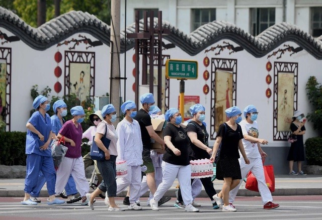 Personal médico llega a un sitio para realizar pruebas sobre coronavirus a personas que viven cerca del mercado Xinfadi, donde se detectaron nuevos casos. Foto Afp 
