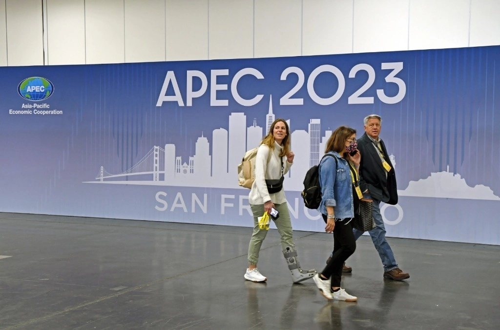 Representantes de los medios de comunicación caminando frente a un cartel en el centro internacional de medios de la APEC 2023, en San Francisco, Estados Unidos. Foto: Xinhua.