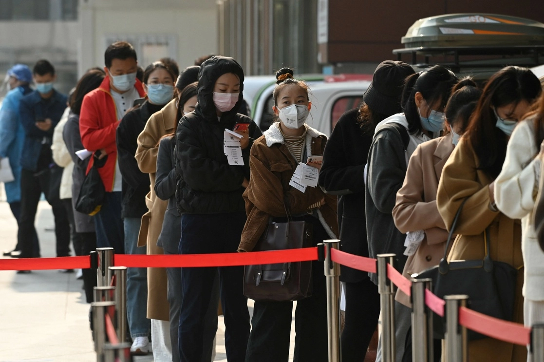 Ciudadanos chinos hacen fila para someterse a una prueba de Covid-19 en Pekín, el 29 de octubre de 2021. Foto Afp