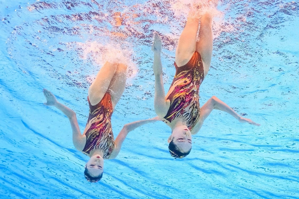Una vista submarina muestra a las chinas Wang Liuyi y Wang Qianyi compitiendo en la rutina libre a dúo del evento de natación artística durante los Juegos Olímpicos de París 2024 en el Centro Acuático de Saint-Denis, al norte de París, el 10 de agosto de 2024. Foto Afp