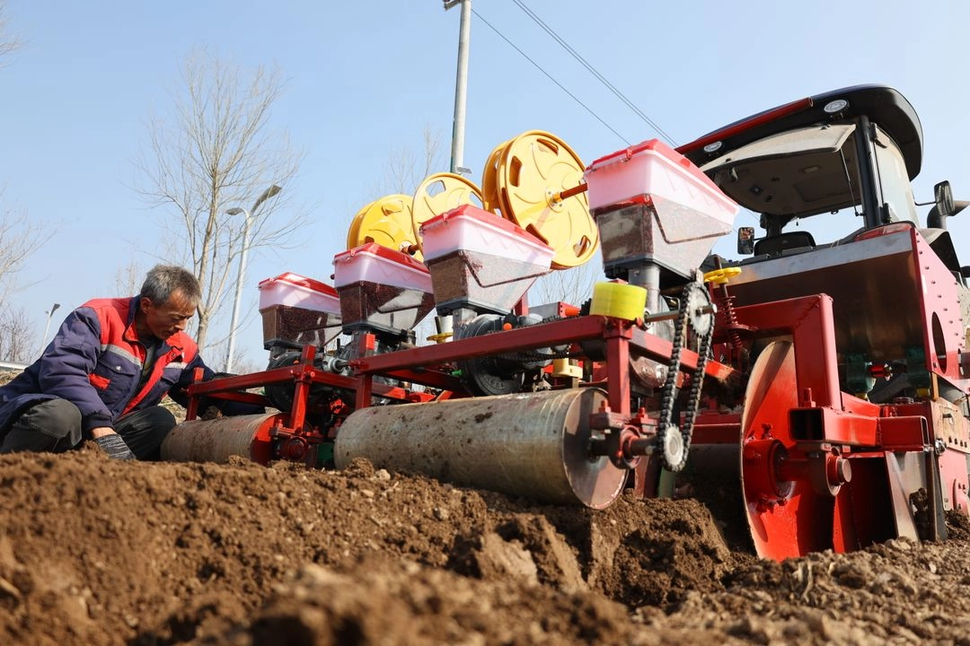 Un hombre limpia maquinaria y equipo agrícola en preparación para sembrar semillas de hierbas medicinales chinas en una tierra de cultivo en la aldea de Nanbeidi, ciudad de Kaifeng, provincia de Henan, en el centro de China, el 8 de marzo de 2025. 